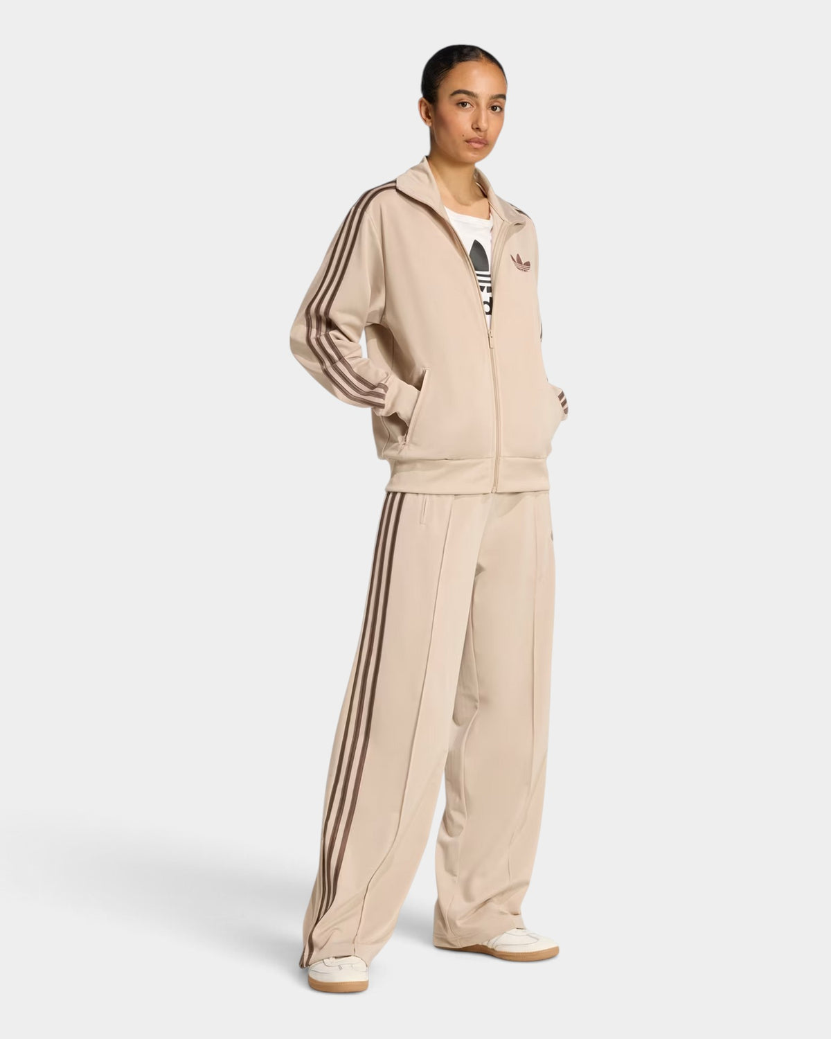 Lockwood Avenue model wearing beige adidas Firebird loose track pants and matching track jacket with 3-Stripes