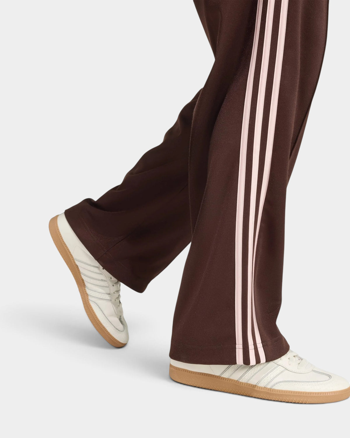 Lockwood Avenue adidas Firebird loose track pants in brown with light pink 3-Stripes worn with white sneakers