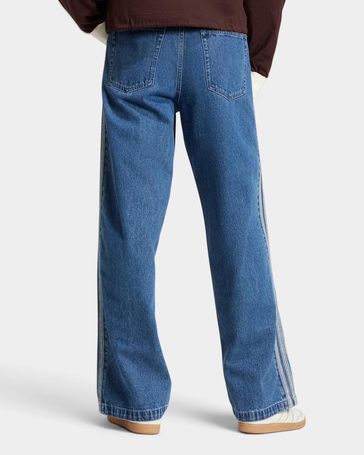 Lockwood Avenue adidas Adicolor denim Firebird pants in blue with iconic 3-Stripes, back view on a model.