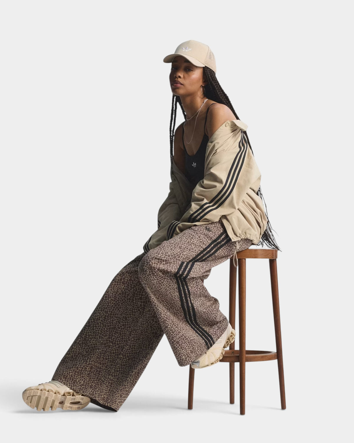 Lockwood Avenue model wearing adidas Firebird oversized denim pants with an all-over print and signature side stripes.