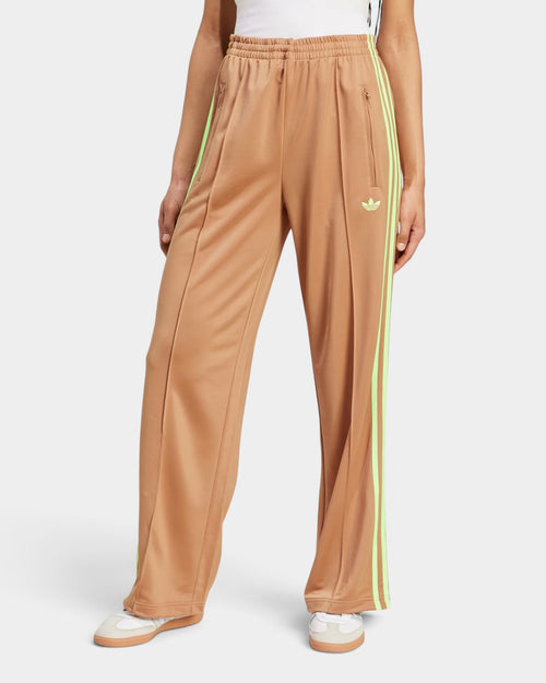 Lockwood Avenue adidas Adicolor Firebird loose track pants in beige with signal green side stripes and zip pockets.