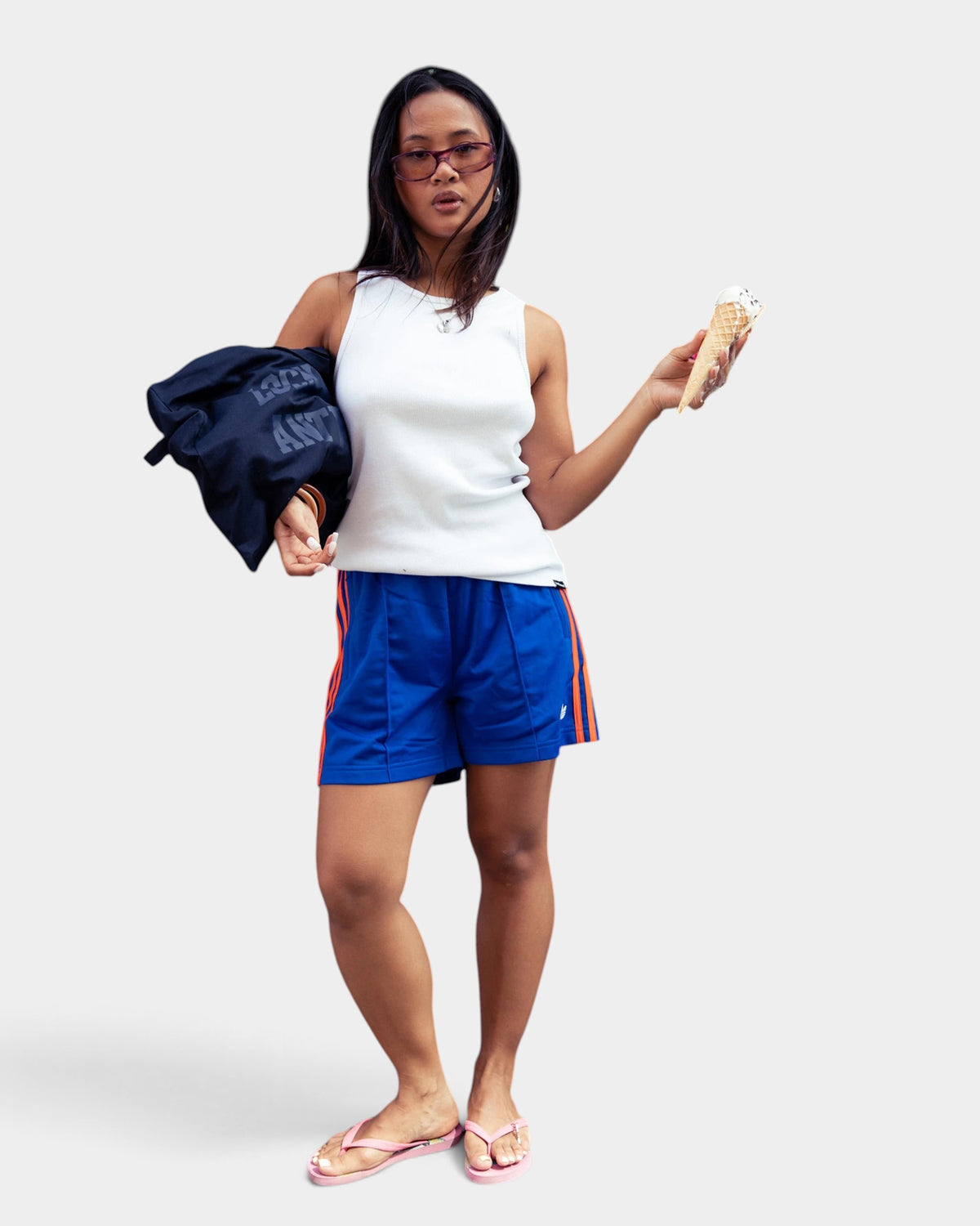 Lockwood Avenue model wearing blue adidas Firebird tricot shorts with orange 3-Stripes and a white tank top