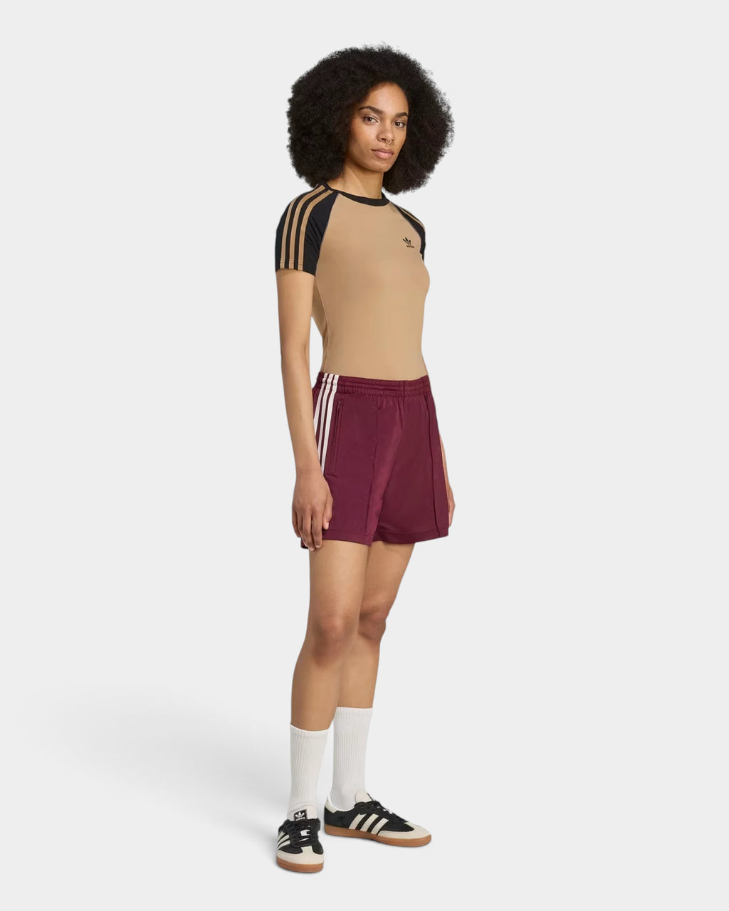 Model wearing Lockwood Avenue adidas Firebird maroon tricot shorts with side zip pockets and elastic waist