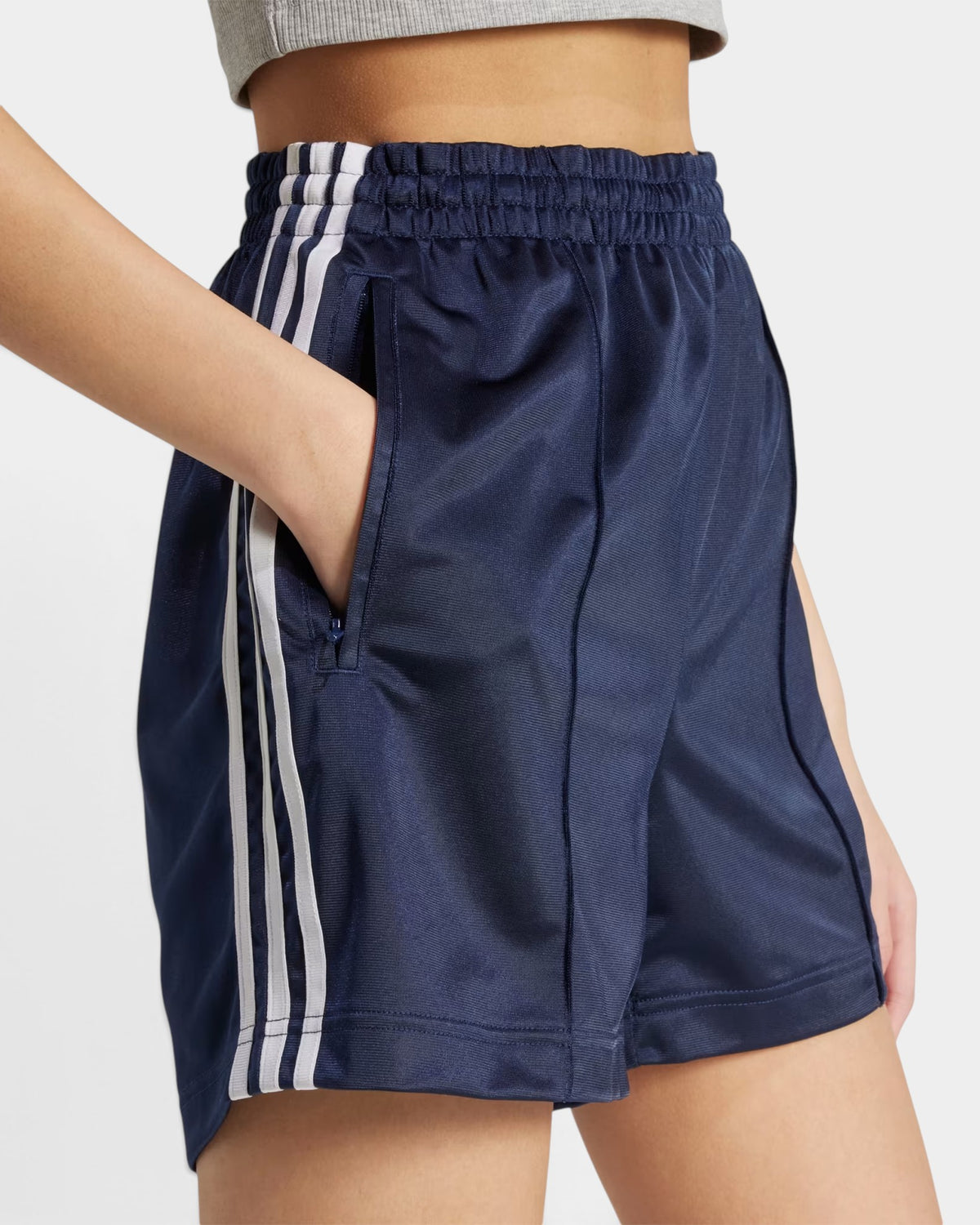 Lockwood Avenue adidas Firebird navy blue tricot shorts with white side stripes and zip pockets on a model