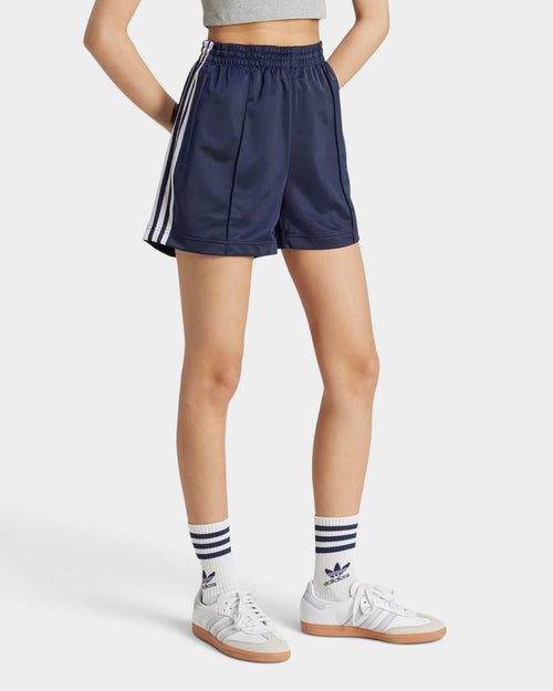 Lockwood Avenue adidas Firebird navy blue tricot shorts with white side stripes and zip pockets on a model