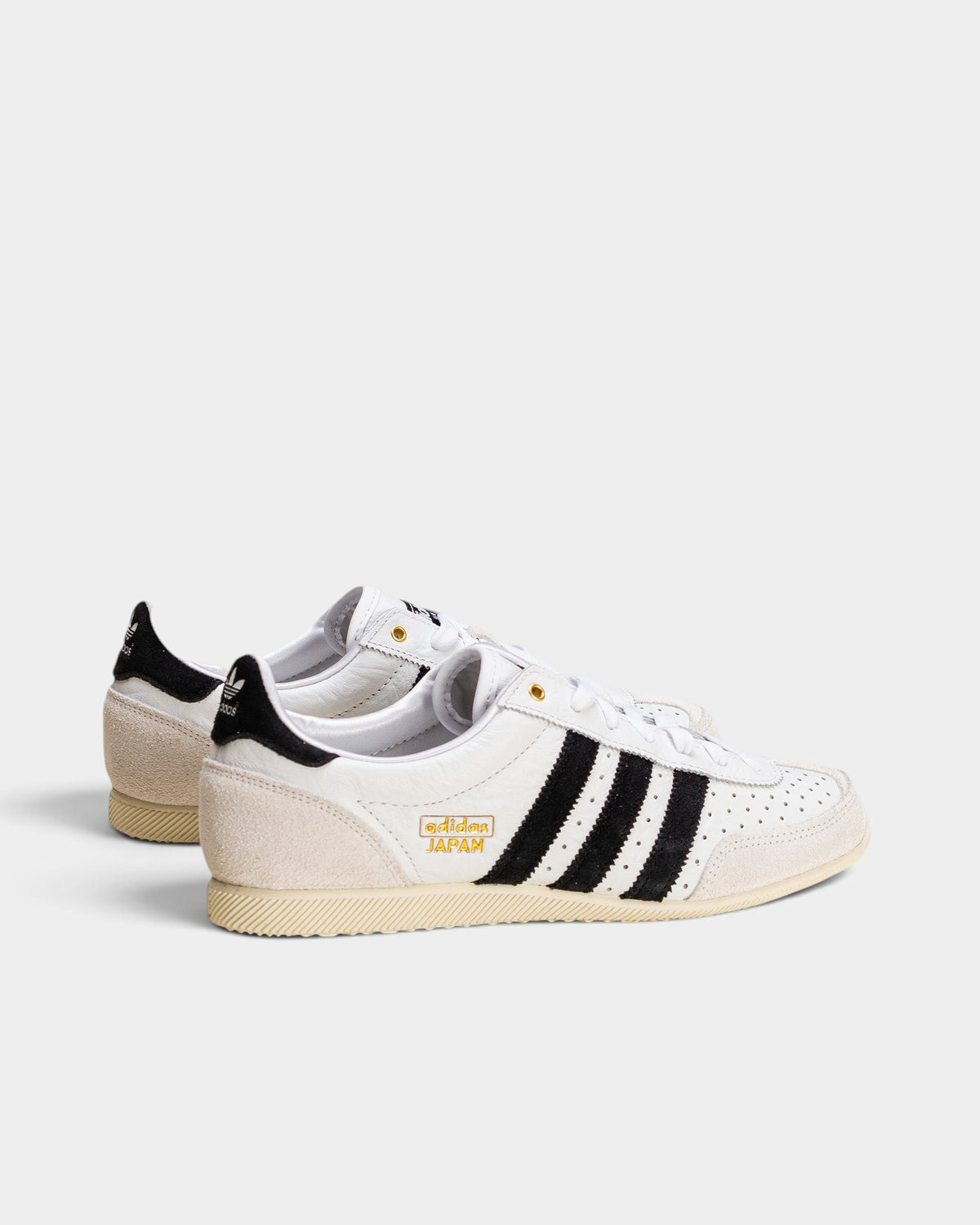 Lockwood Avenue adidas Japan women's trainers in white perforated leather with black stripes and gold detailing.