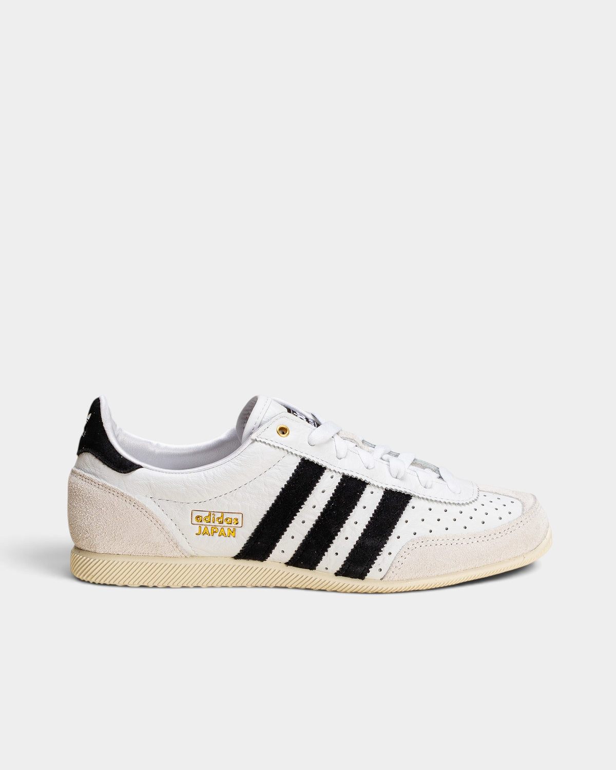 Lockwood Avenue adidas Japan women's trainer in white perforated leather with black stripes and gold logo detailing.