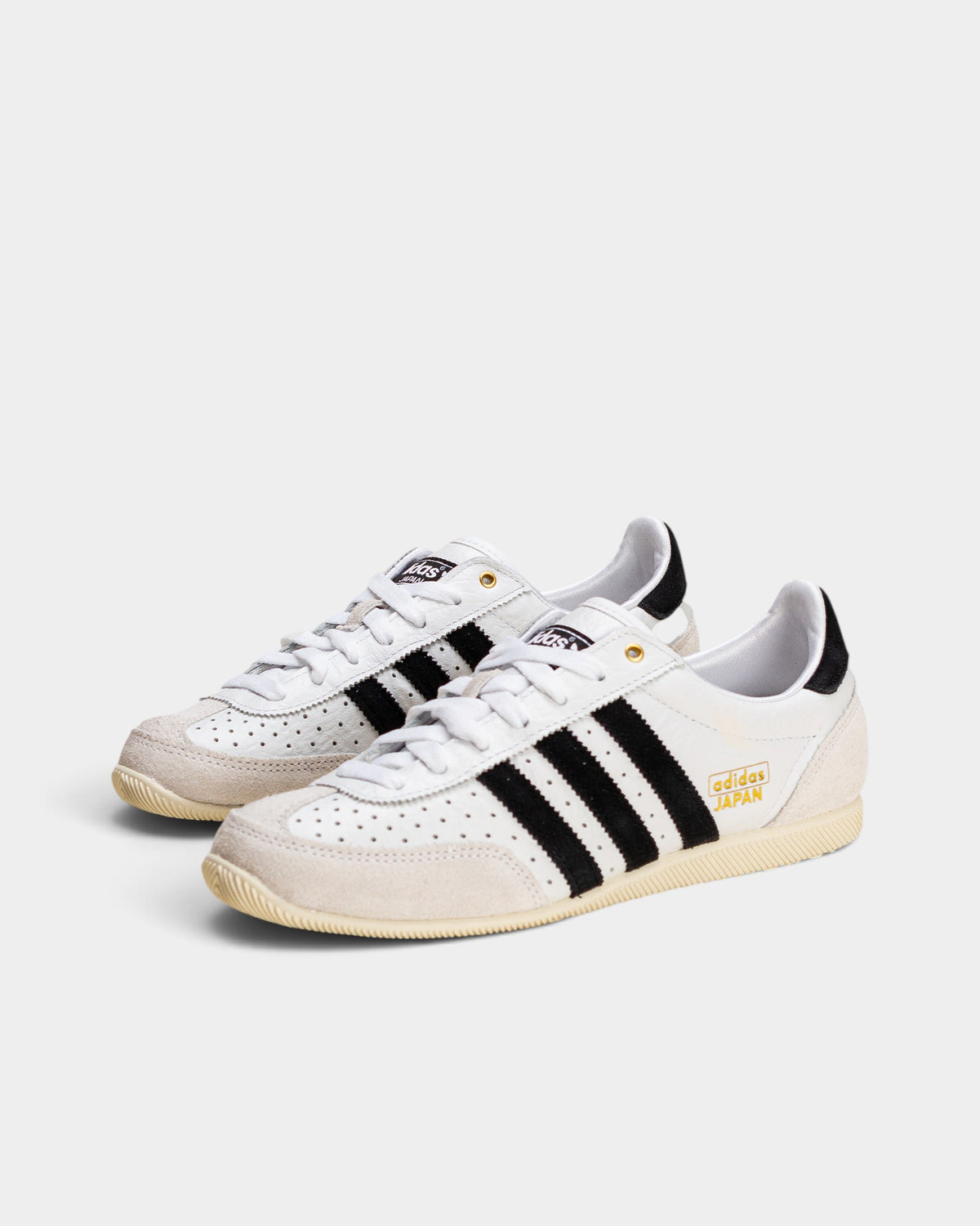 Lockwood Avenue adidas Japan women's trainers in white perforated leather with black stripes and gold accents.