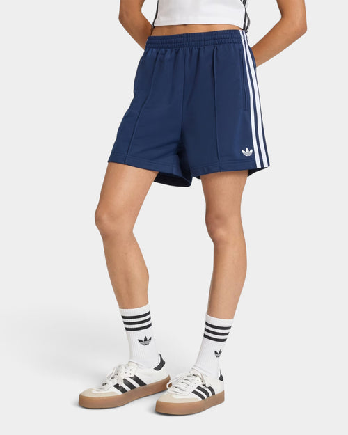 Lockwood Avenue adidas Firebird navy blue tricot shorts with white 3-Stripes and mid-rise waist on a model