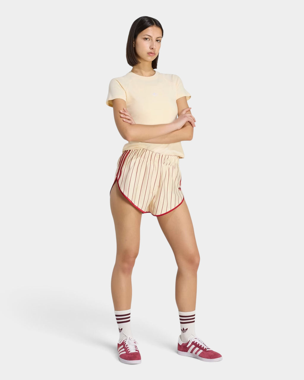 Lockwood Avenue model wearing adidas pinstripe loose fit polyester shorts with red trim and matching sneakers