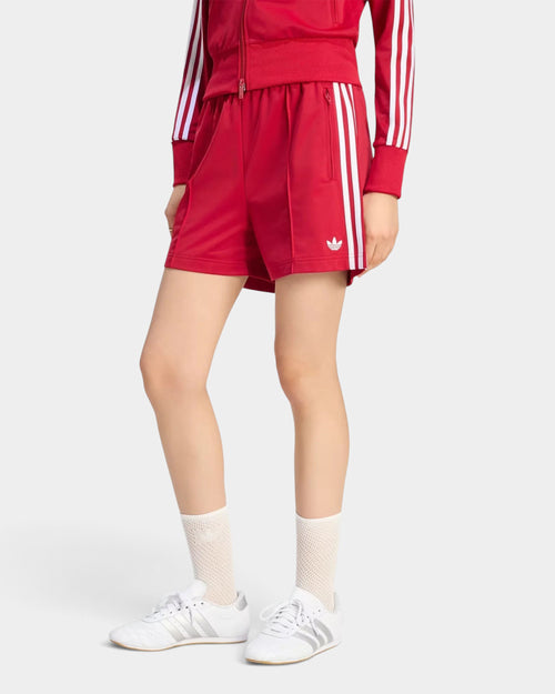 Lockwood Avenue adidas Firebird red tricot shorts with white 3-Stripes and mid-rise waist on a model