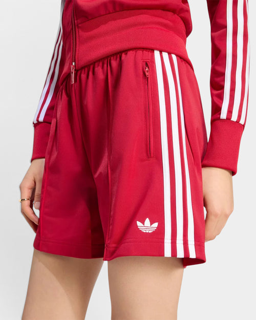 Lockwood Avenue adidas Firebird red tricot shorts with white 3-Stripes and trefoil logo on a model