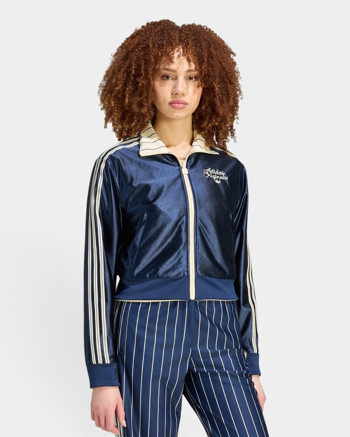 Lockwood Avenue model wearing a navy blue adidas Reversible Firebird Track Top with cream stripes and collar.