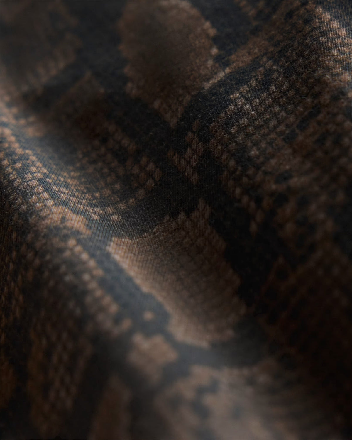 Close-up of Lockwood Avenue adidas snake print cotton jersey fabric in dark brown and black tones