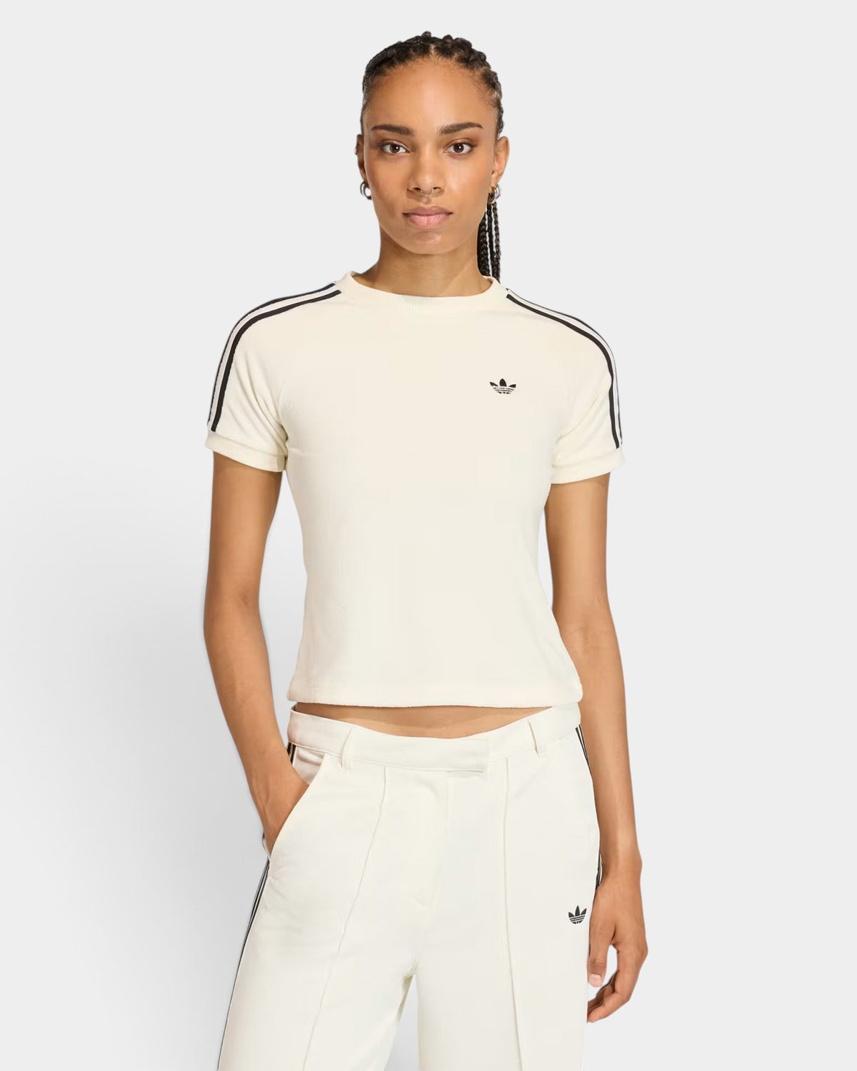 Model wearing a cream Lockwood Avenue adidas Terry Towel Cali slim-fit t-shirt with black three-stripe sleeve detail.