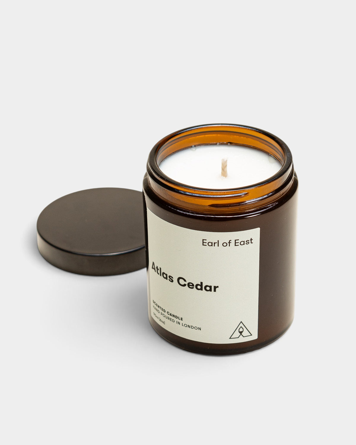 Lockwood Avenue Earl of East Atlas Cedar soy wax candle in an amber glass jar with a black lid on a white background