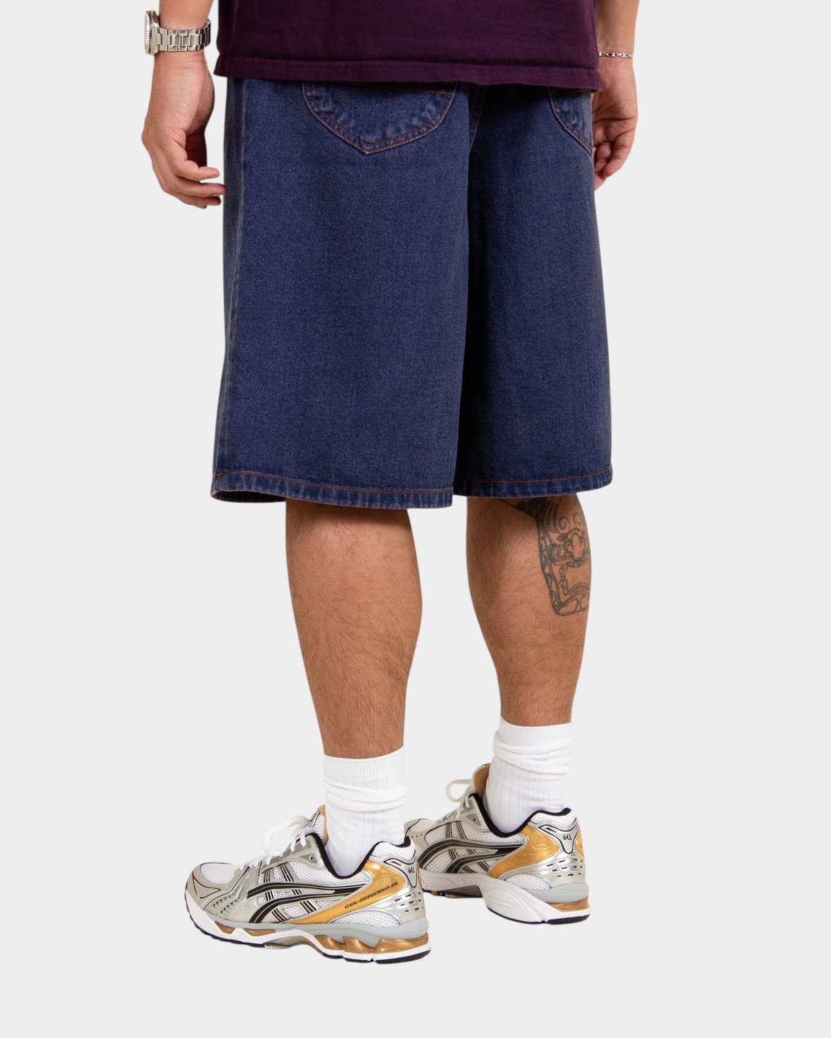 Lockwood Avenue baggy denim shorts in overdye blue cotton with angular back pockets worn by a model