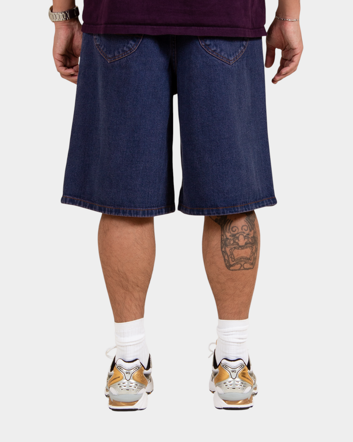 Lockwood Avenue baggy denim shorts in dark blue overdye cotton with angular back pockets, back view on model