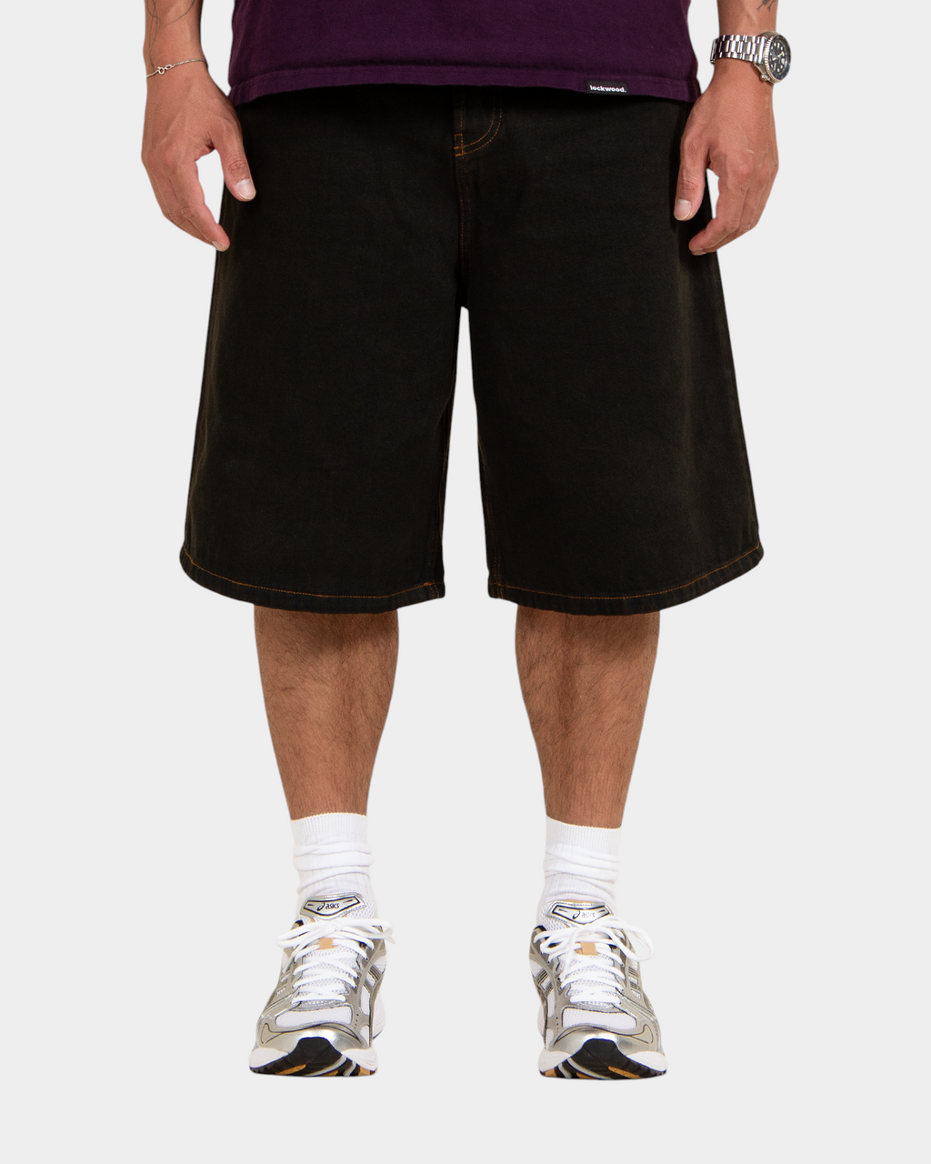 Lockwood Avenue baggy denim shorts in overdye black cotton with angular back pockets and button fly on a model