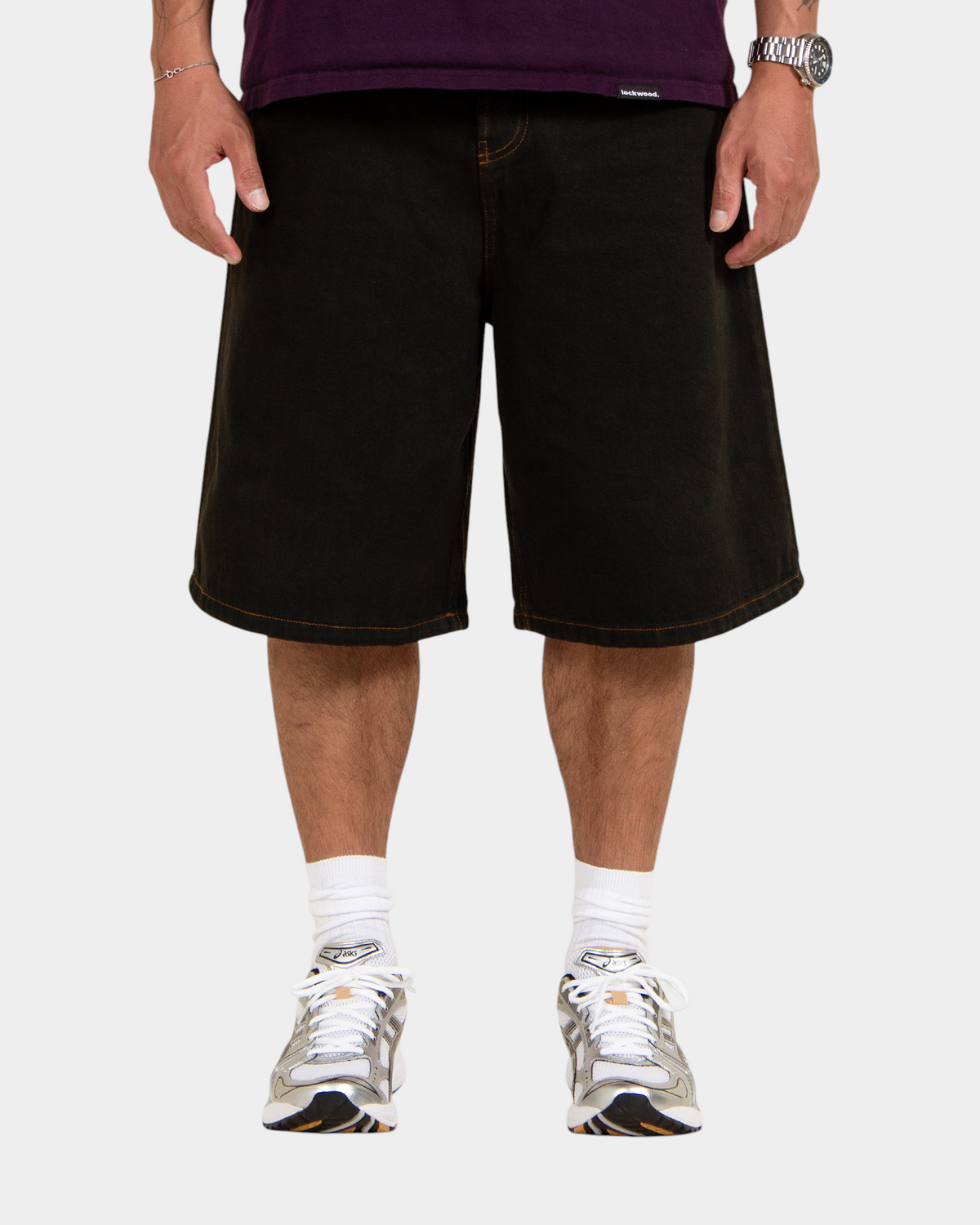Lockwood Avenue baggy denim shorts in overdye black cotton with angular back pockets and button fly on a model
