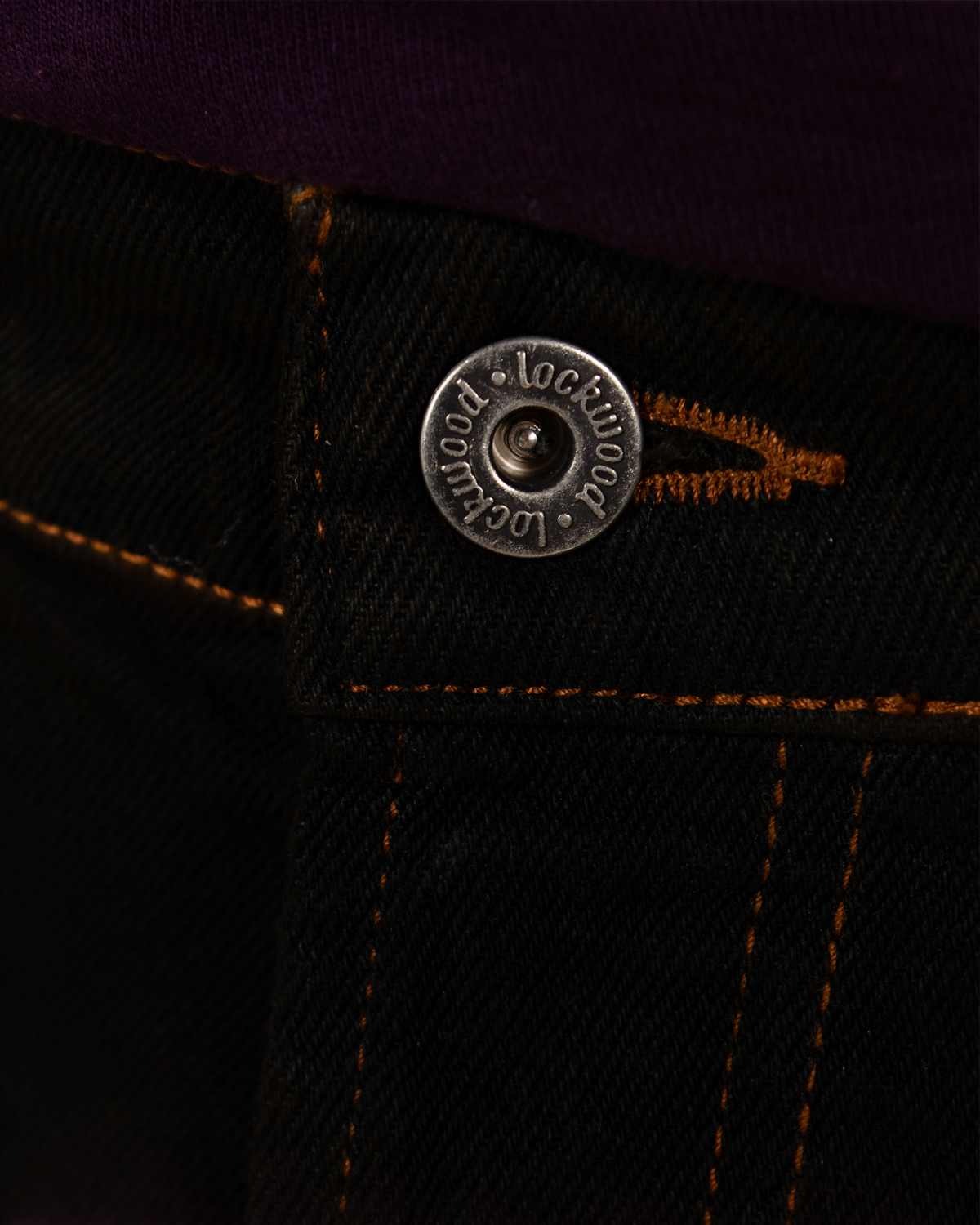 Lockwood Avenue baggy jeans featuring a metal button with engraved brand logo and contrast stitching