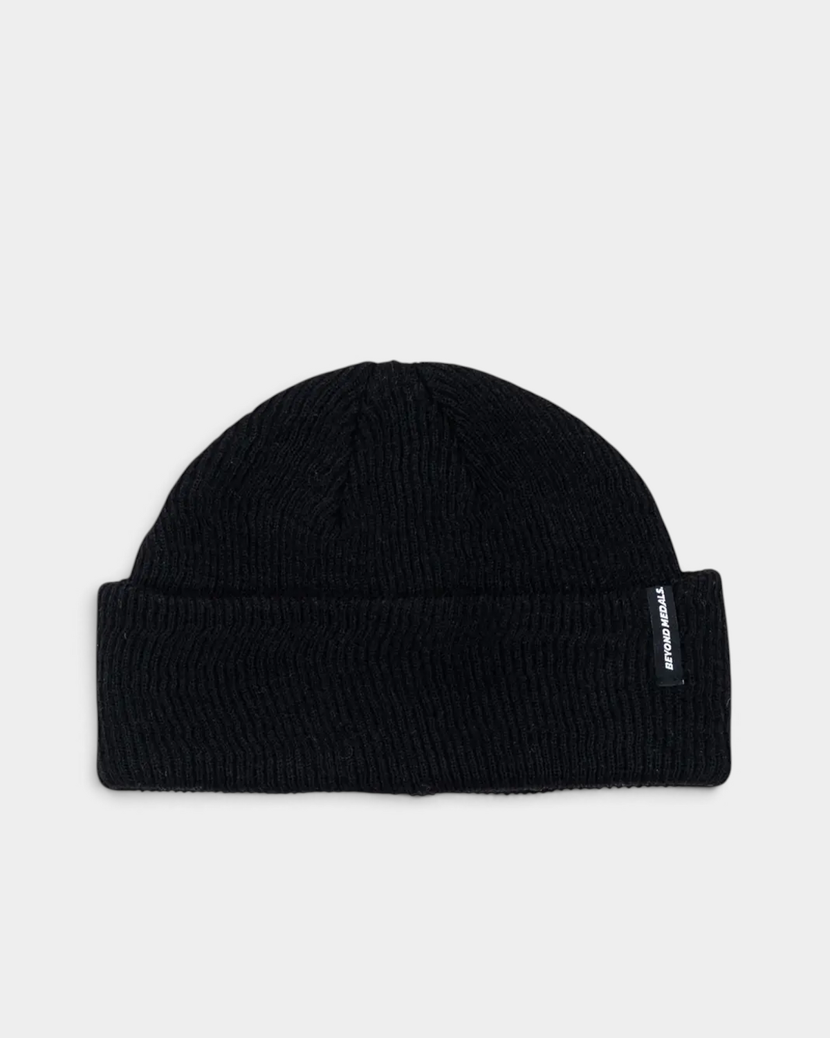 Lockwood Avenue Beyond Medals black rib knit short-fit beanie with a folded cuff and small woven logo tab.
