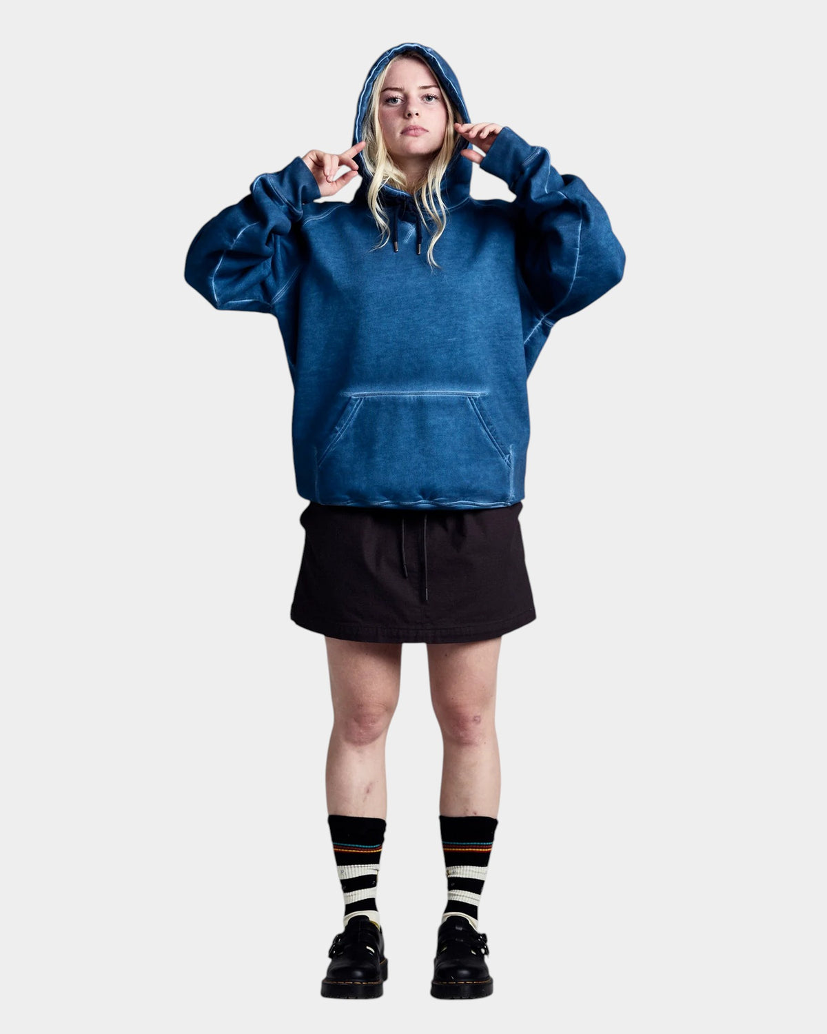 Lockwood Avenue model wearing a blue garment-dyed heavyweight cotton Pop Trading Company stencil logo hoodie