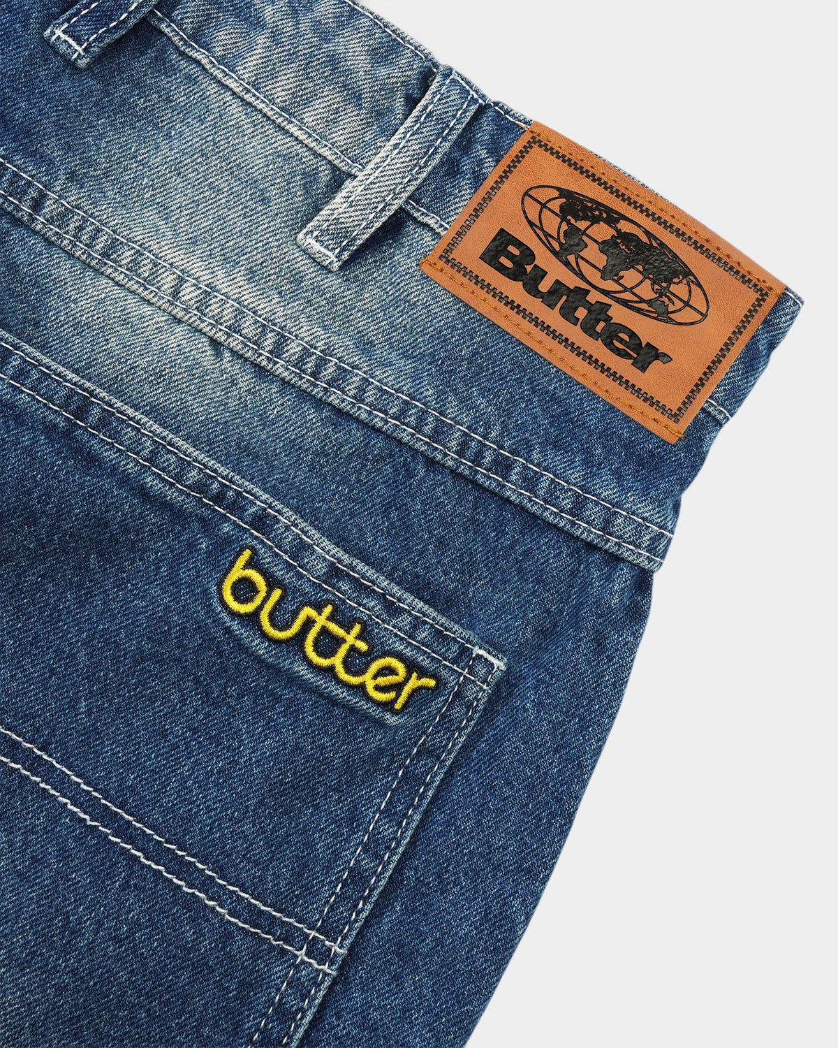 Lockwood Avenue Butter Goods Alpine denim jeans featuring a faded blue wash, leather waistband patch, and logo pocket