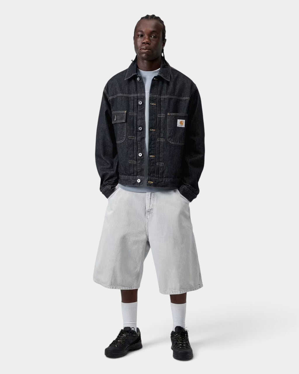 Lockwood Avenue model wearing a black Carhartt Belmar denim jacket with chest pockets and a square logo label