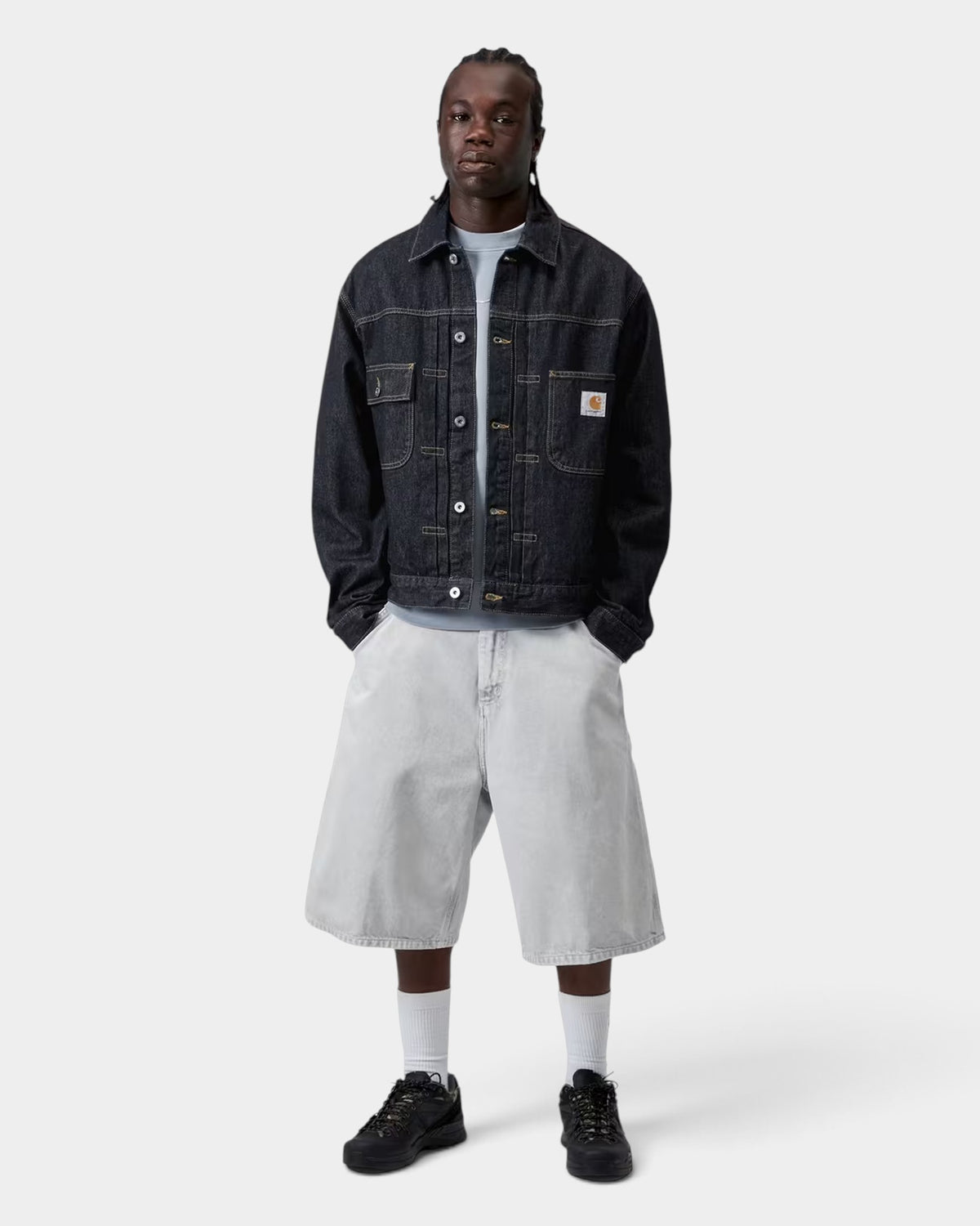 Lockwood Avenue model wearing a black Carhartt Belmar denim jacket with chest pockets and a square logo label