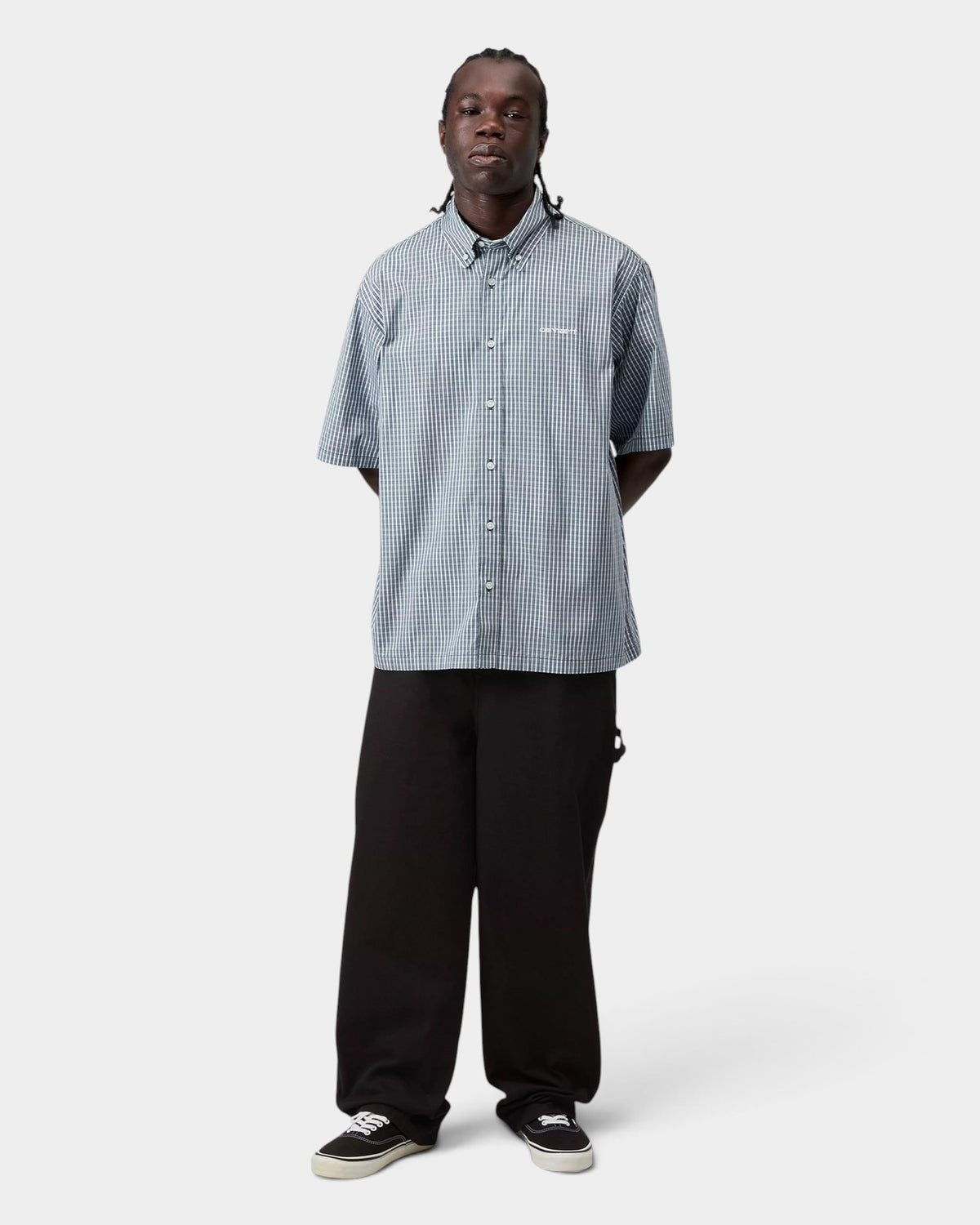 Model wearing a Lockwood Avenue Carhartt Groff short-sleeve blue check cotton poplin shirt with a button-down collar.