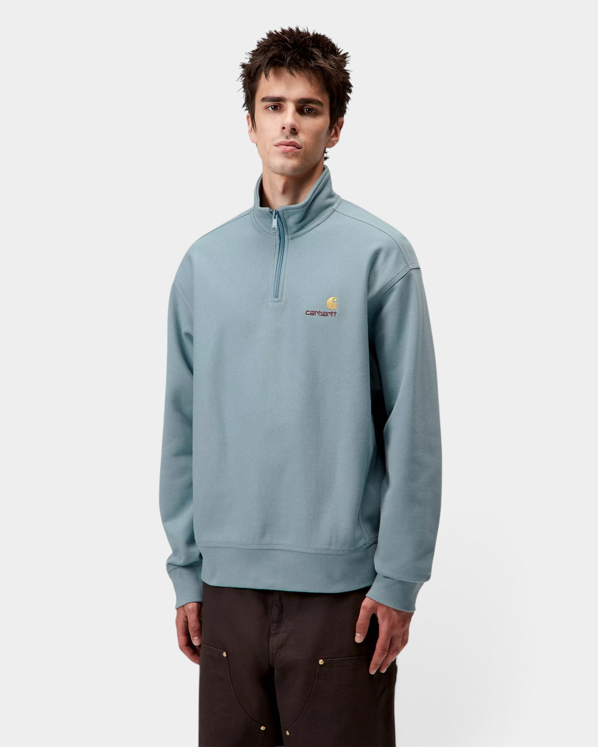 Lockwood Avenue model wearing a light blue Carhartt American Script half-zip sweatshirt with embroidered logo