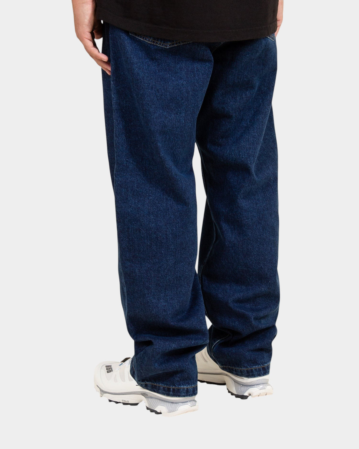 Lockwood Avenue Carhartt Landon loose tapered blue denim pants seen from the back with white sneakers