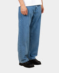 Lockwood Avenue Carhartt Landon stone-washed blue denim pants in a loose tapered fit worn by a model