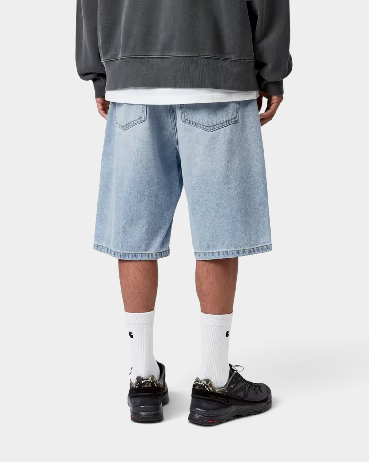 Rear view of a person wearing Lockwood Avenue Carhartt Landon light blue denim shorts with a loose fit and back pockets