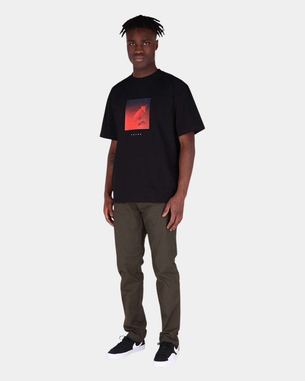 Lockwood Avenue model wearing Carhartt Sid slim tapered olive chino pants and a black graphic t-shirt