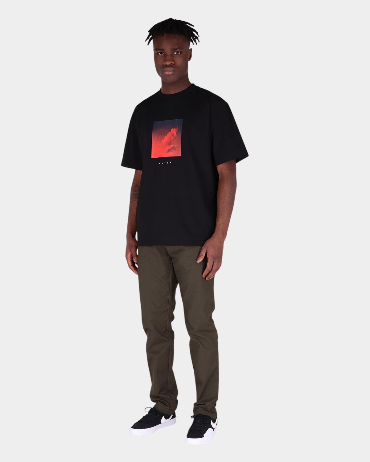 Lockwood Avenue model wearing Carhartt Sid slim tapered olive chino pants and a black graphic t-shirt