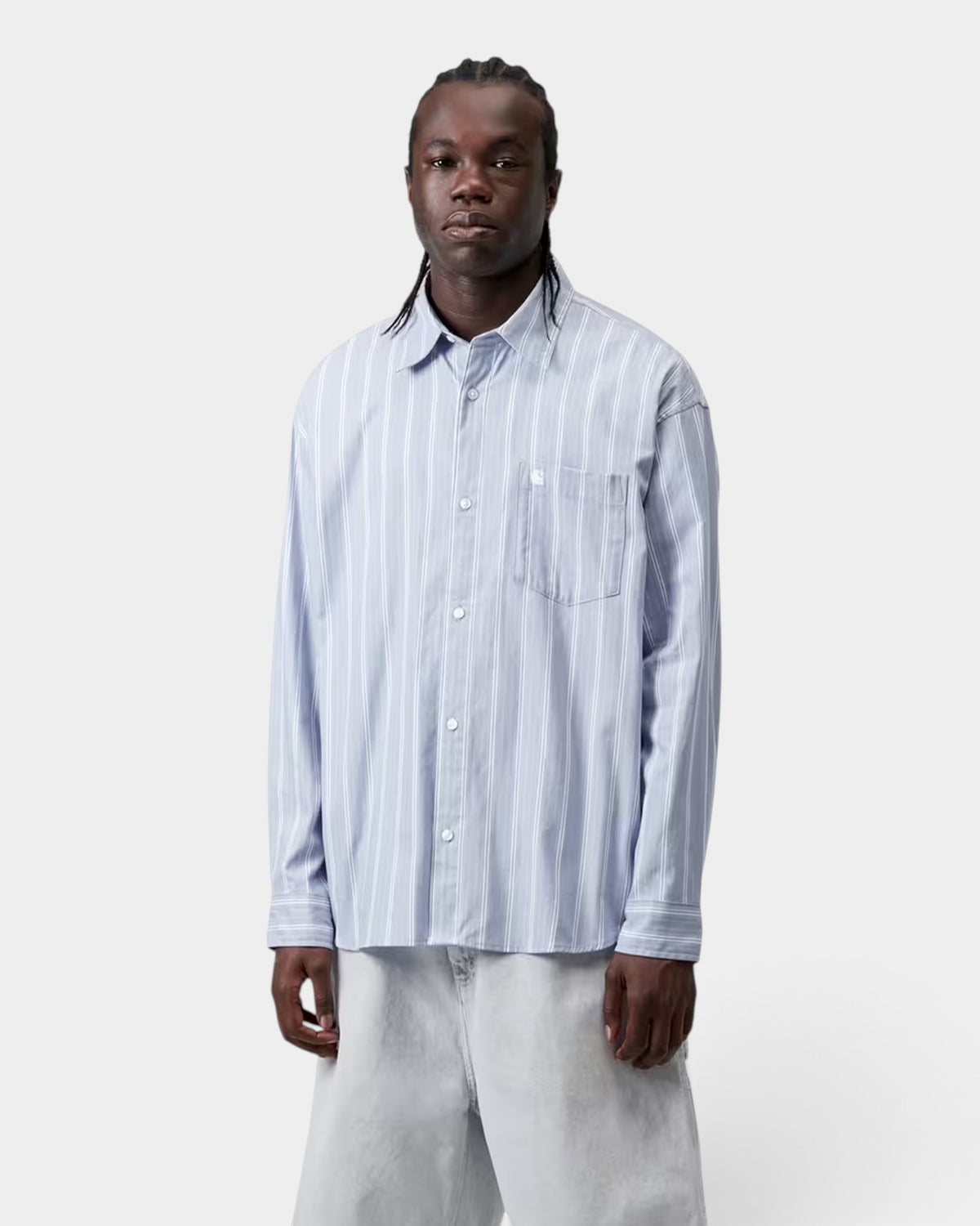 Lockwood Avenue model wearing a loose fit light blue striped dobby cotton long-sleeve shirt with a chest pocket.