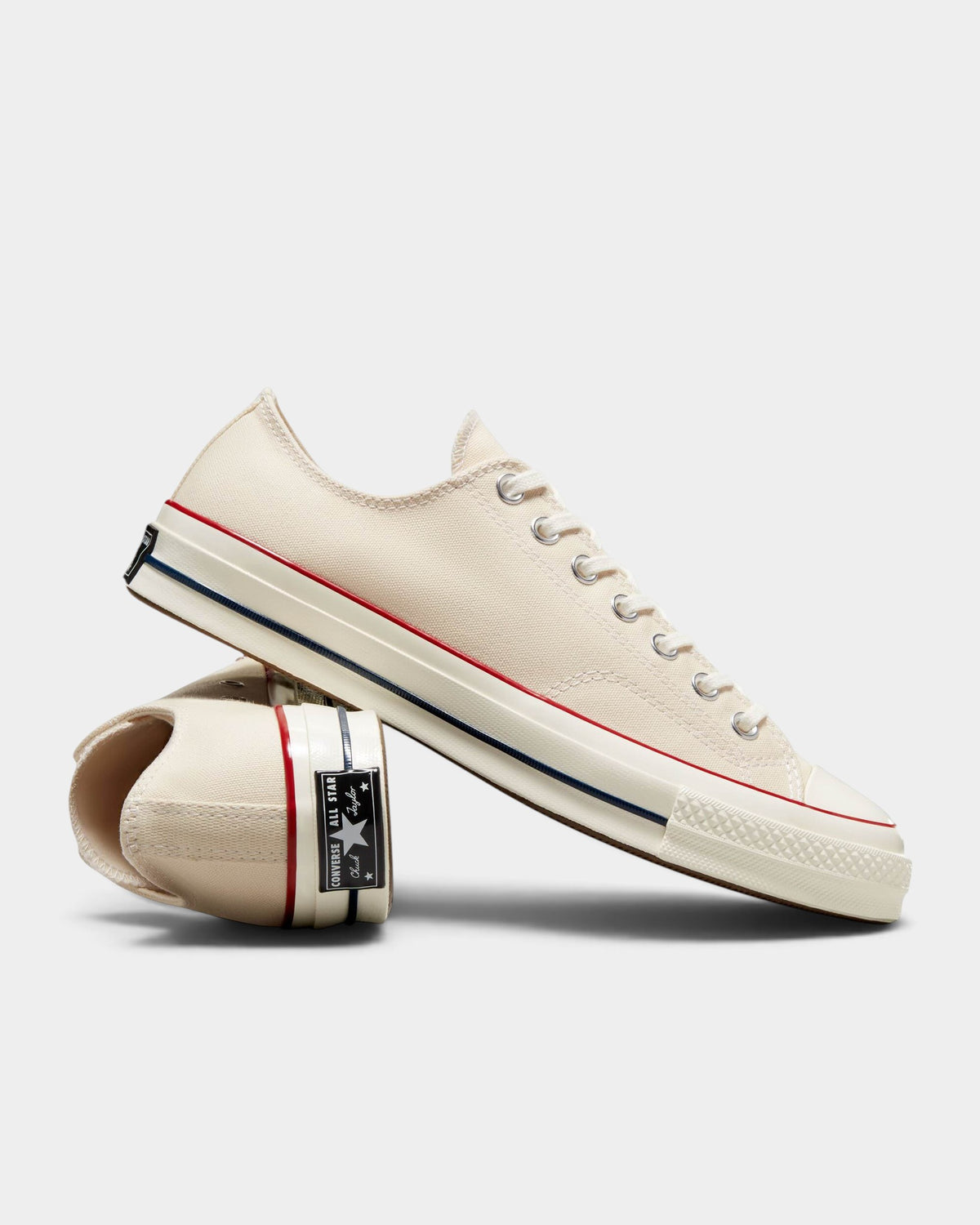 Lockwood Avenue Converse Chuck 70 low-top sneakers in parchment canvas with garnet and egret trim and rubber toe cap.