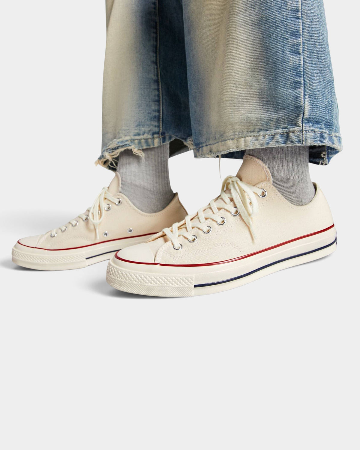 Lockwood Avenue Converse Chuck 70 low-top sneakers in parchment canvas with egret midsole and garnet trim on feet