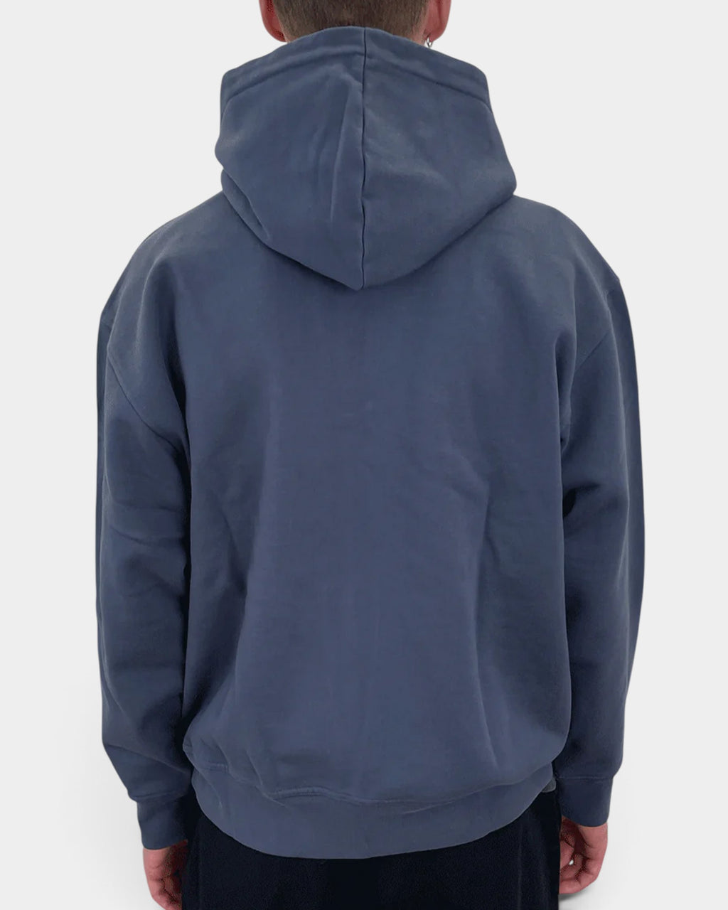 Back view of a person wearing a navy blue Lockwood Avenue Dancer organic cotton zip hoodie with a hood up.
