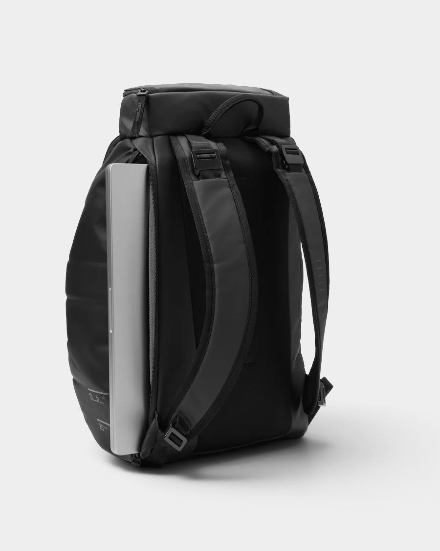 Lockwood Avenue DB Journey Hugger 25L black backpack with a laptop partially inserted into the side compartment.