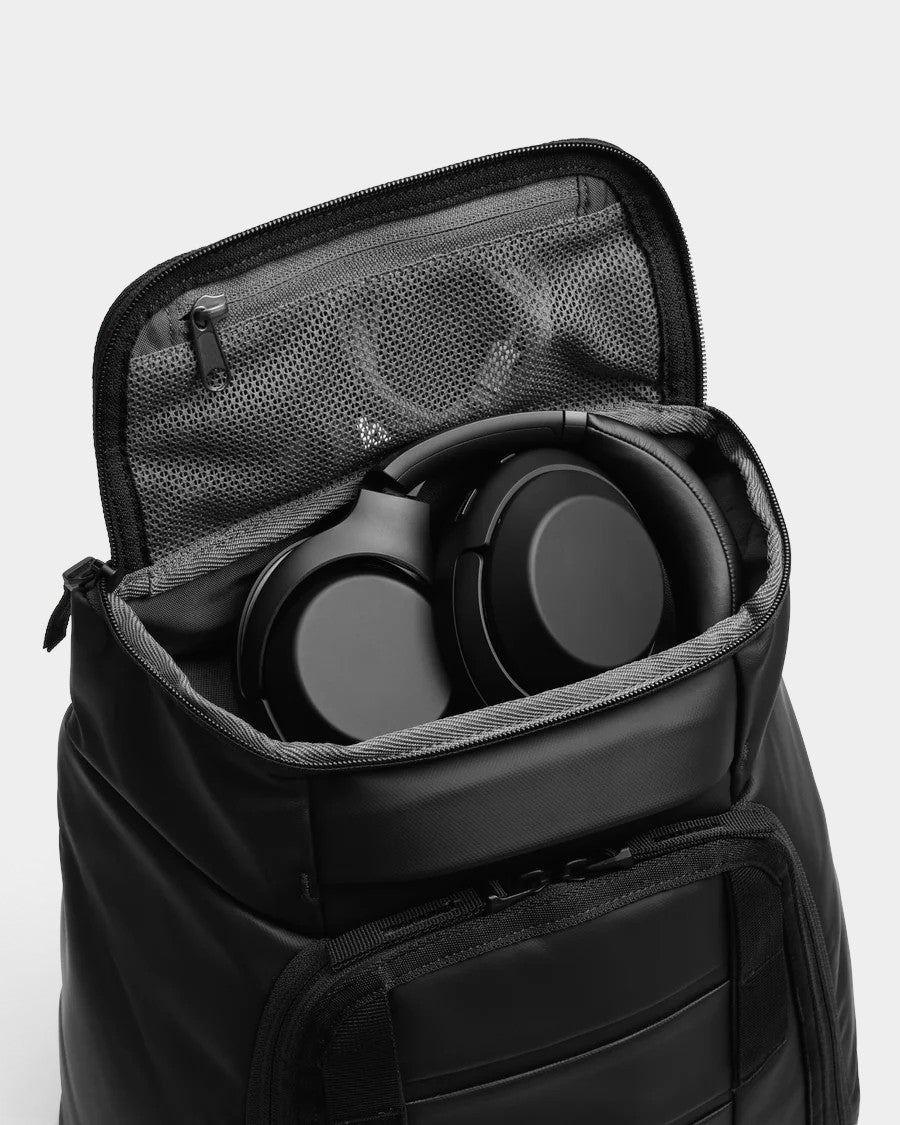 Lockwood Avenue DB Journey Hugger 25L black backpack with open main compartment containing black headphones