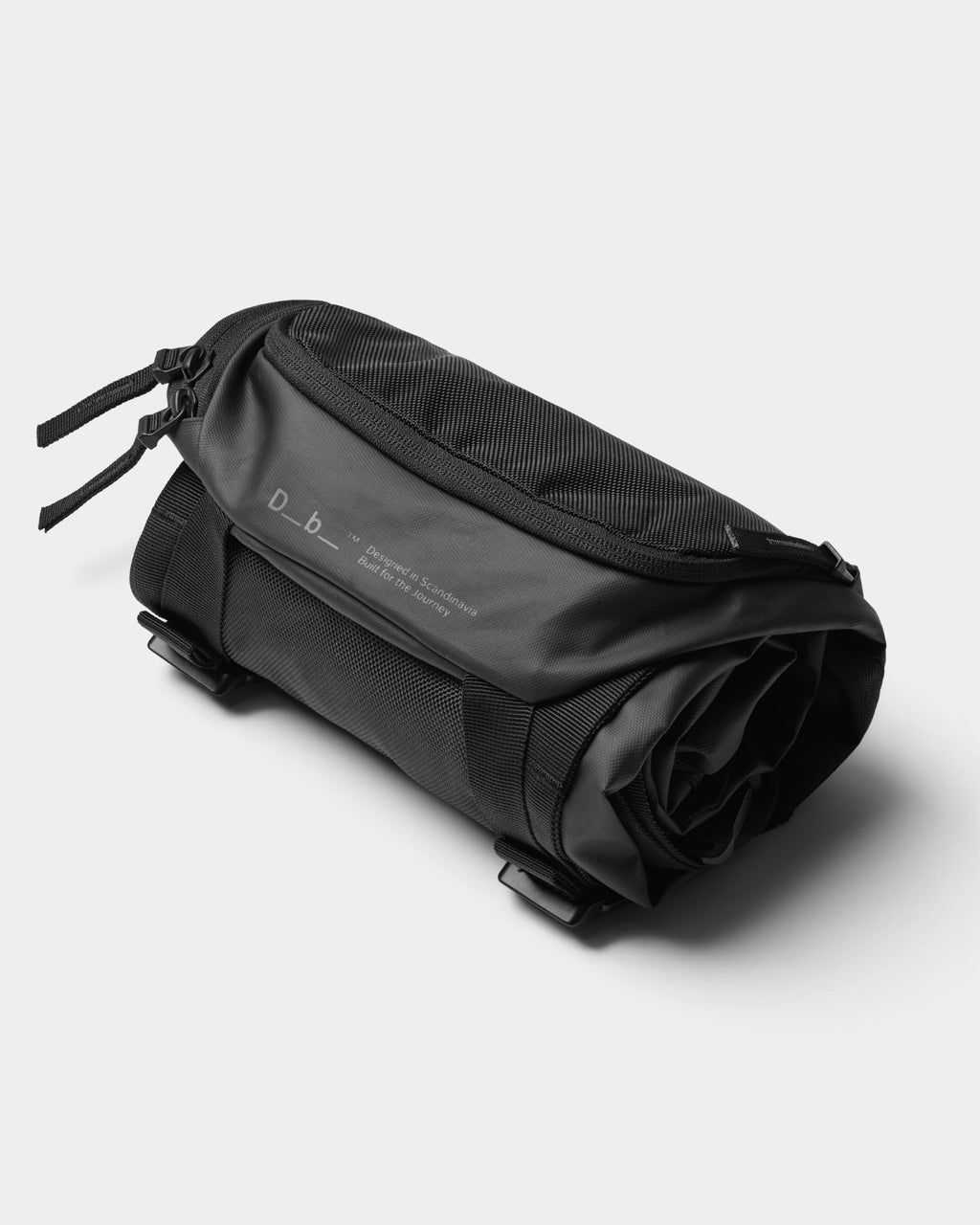 Lockwood Avenue DB Journey Skate 32L Carrier in black, shown in a compact, rolled-up packable storage state.
