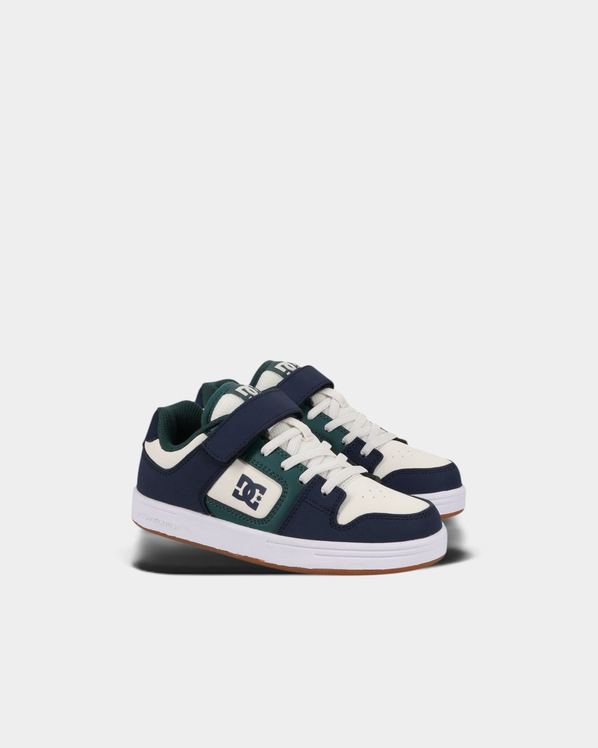 Lockwood Avenue DC Manteca 4 kids skate shoes in navy, white, and green with velcro strap and rubber cupsole.