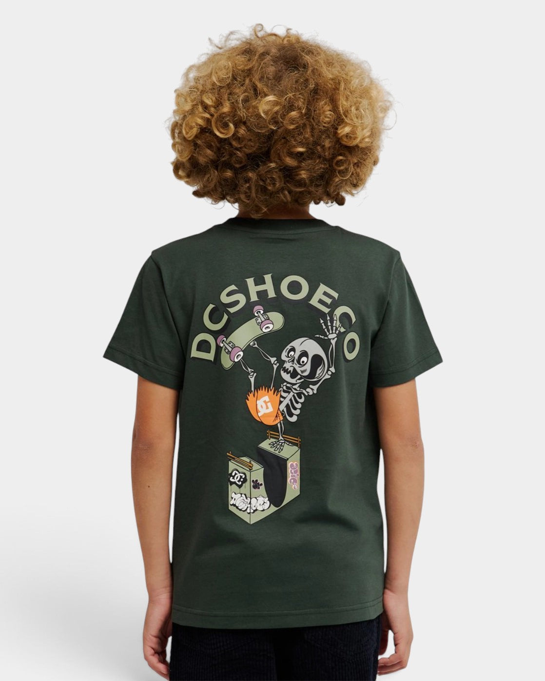 Lockwood Avenue youth wearing a dark green DC Shoes cotton jersey t-shirt with a skeleton handplant graphic on the back