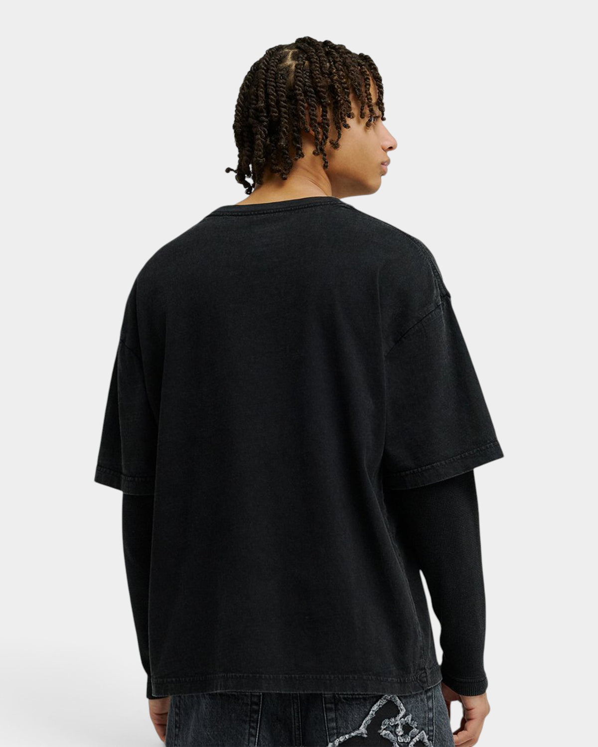 A model wearing a black DC Twofer long-sleeve t-shirt from Lockwood Avenue, viewed from the back.