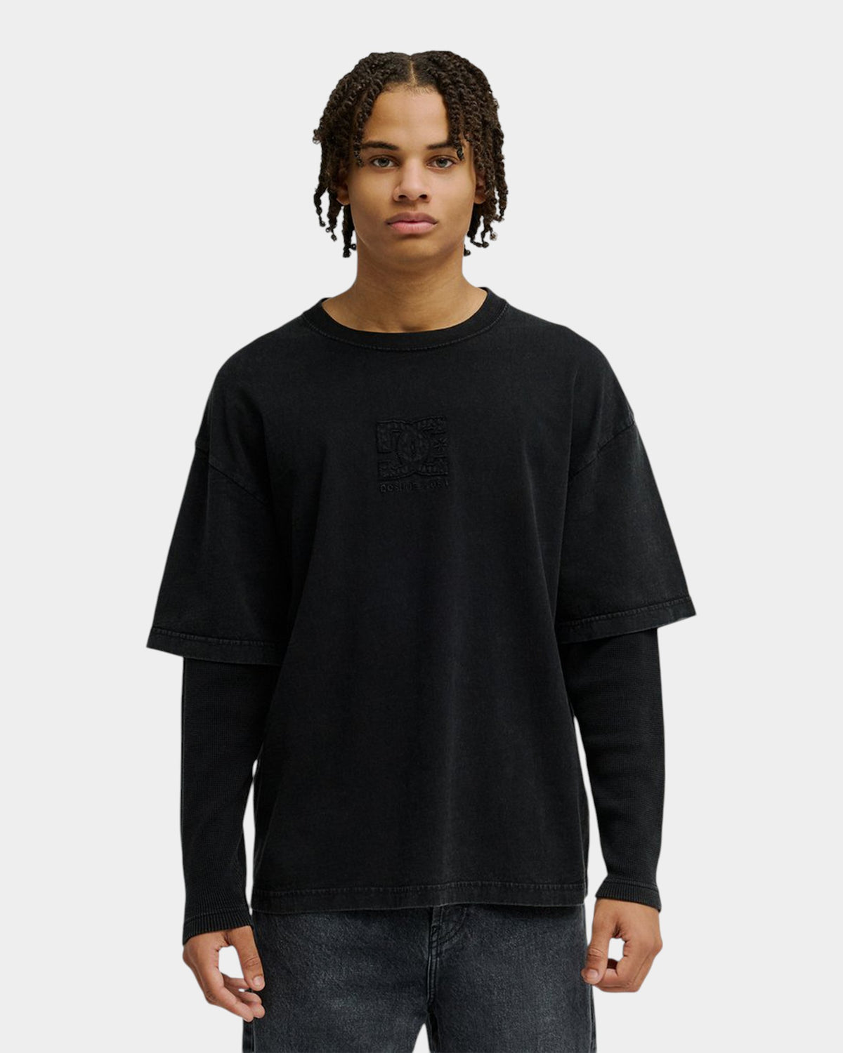 A model wearing a black Lockwood Avenue DC Twofer long-sleeve t-shirt with a layered effect and embossed logo detail.