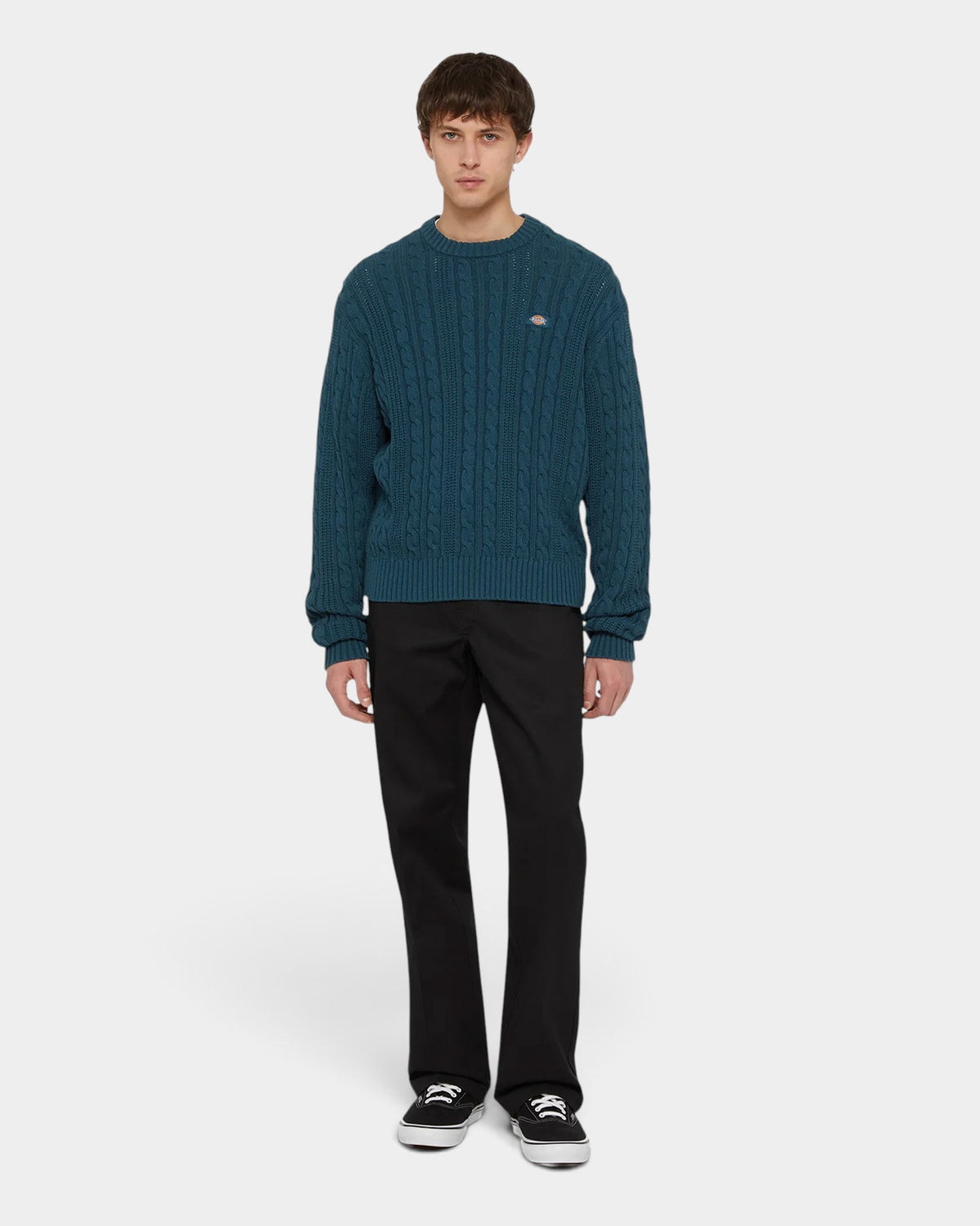 Lockwood Avenue model wearing black Dickies 874 recycled work pants with a teal cable knit sweater and black sneakers.
