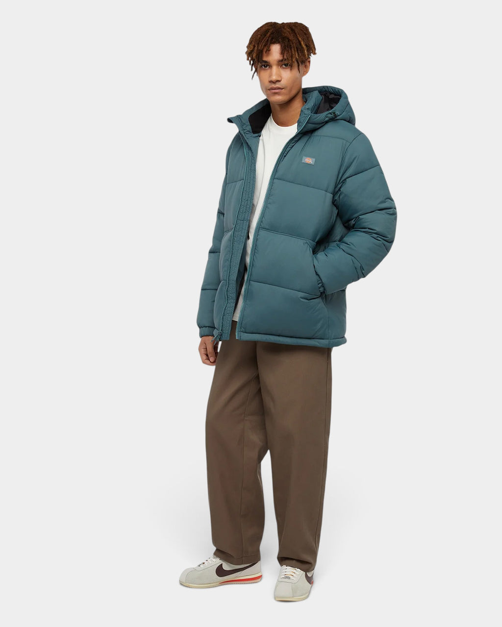 Lockwood Avenue model wearing a teal hooded puffer jacket and brown Dickies 247 loose fit work pants
